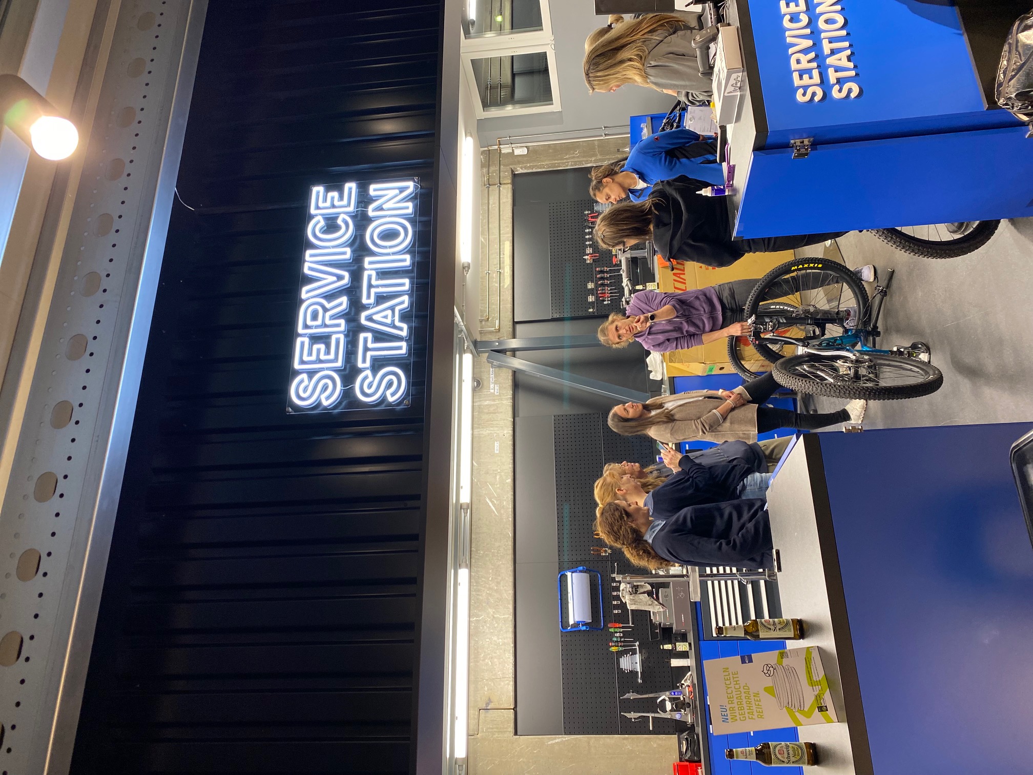 Frauen bei einer Fahrrad-Erklärung an der Service Station von Alpha Bikes
